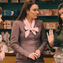 a woman in a gray suit has a brooch on her collar that says ' elena '