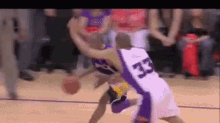 a basketball player with the number 33 on his jersey is trying to block another player