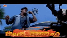 a man is standing next to a car in a movie .