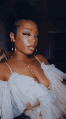 a woman wearing a white off the shoulder top