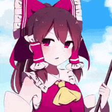 a girl with a red bow on her head is holding a stick in her hand .