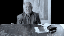 a man sitting at a desk with the name michalek written on the bottom