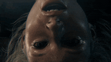 a close up of a person 's face with a beard and black eyes