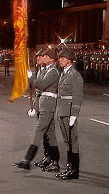 a group of soldiers marching in a parade holding flags