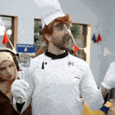 a man in a chef costume holds a spatula in front of a blue sign that says potato palace