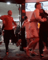 a group of people are dancing in front of a sign that says ' less shopping '