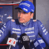 a man wearing a blue hat that says atlassian williams racing on it