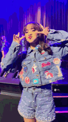 a girl wearing a denim jacket and shorts with pearls on them