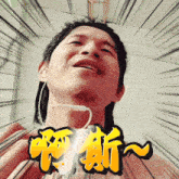 a man wearing ear buds looks up at the camera with chinese characters behind him