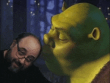 a man with glasses looks at shrek 's face in a painting
