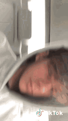 a tiktok video of a woman sleeping in a bed