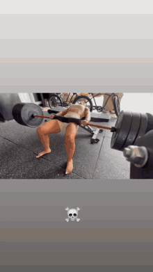 a woman is doing a bench press with a skull and crossbones on the bottom