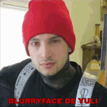 a blurry picture of a man wearing a red hat with the words blurryface de yuli below him