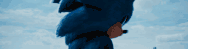 a close up of a blue sonic the hedgehog standing in front of a blue sky