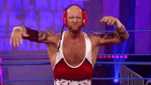 a wrestler wearing headphones is flexing his muscles
