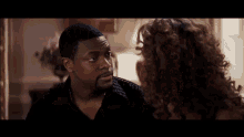 a man and a woman are talking to each other in a room