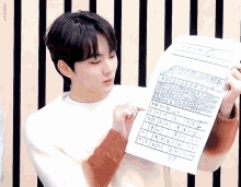 a boy is holding a piece of paper with numbers on it and the word dreamyhead written on the bottom
