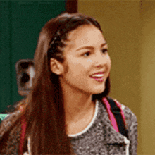 a close up of a woman 's face with long hair and a braided headband .
