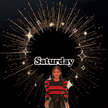 a woman in a red and black striped shirt is dancing in front of a fireworks display that says enjoy saturday