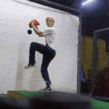 a young man in a white shirt is throwing a ball
