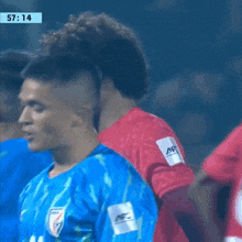 a soccer player wearing a blue jersey with india on the front