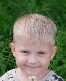 a young boy is holding a white flower in his hand and smiling .