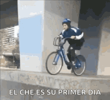 a man is riding a bike on a ramp under a bridge with the caption el che es su primer dia .
