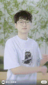 a man wearing glasses and a white t-shirt with a cat on it