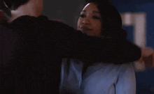 a man and a woman hugging each other in a dark room .