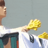 a person holding a pair of yellow gloves with the letter g on it