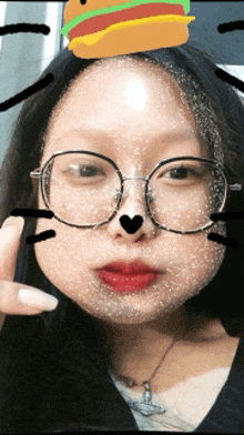 a girl wearing glasses has a hamburger on her forehead