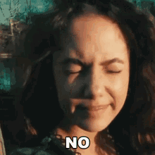 a woman is making a face with her eyes closed and the word no is on her face