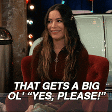 a woman is sitting in a red chair with the words that gets a big ol " yes please " behind her