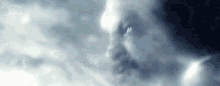 a close up of a person 's face in the clouds with a beard .