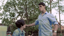a man in a blue shirt is standing next to a woman in a blue shirt