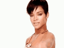 a woman with short hair and a necklace is pointing at the camera .