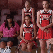 a group of cheerleaders wearing wmhs uniforms sitting in chairs