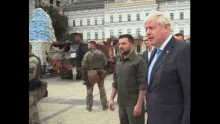 a man in a suit and tie talks to another man
