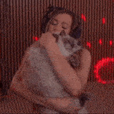 a woman in headphones is holding a cat