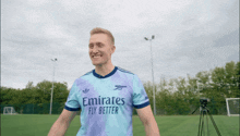 a man wearing a purple emirates fly better jersey