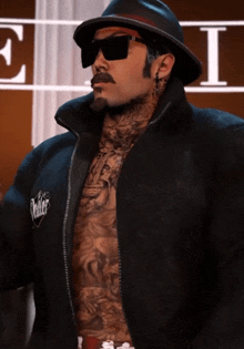 a man with a hat and sunglasses has the word killer on his shirt