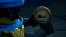 a lego figure is holding a ball that has a face on it