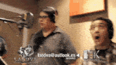 two men are standing in front of a microphone and a sign that says laedva @ outlook.es informes