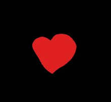 a red heart on a black background that looks like it is floating in the air