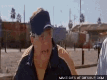 a gif of a man wearing a visor and sunglasses