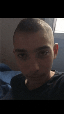 a young boy with a shaved head is looking at the camera