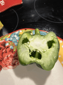a green pepper has a face cut out of it