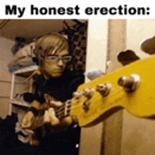 a man wearing headphones is playing a guitar in a room .