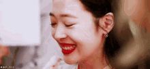 a close up of a woman 's face with red lipstick