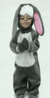 a little girl dressed in a bunny costume is dancing